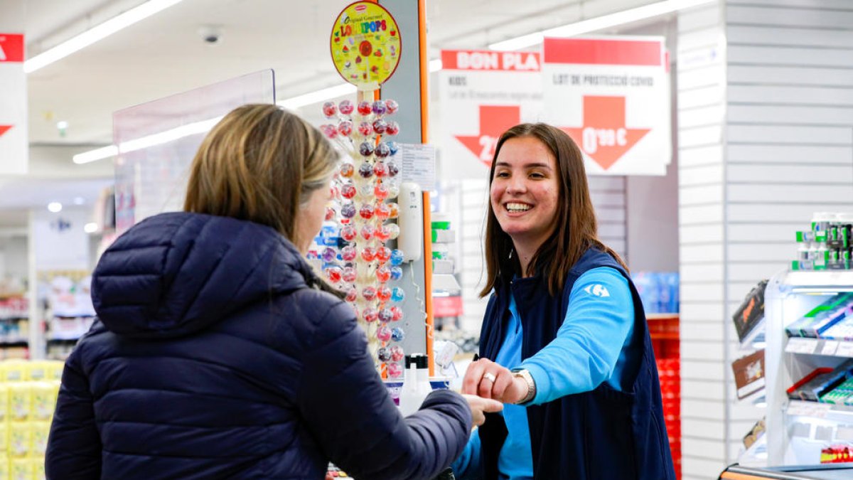 Una treballadora d'un supermercat i una clienta sense mascareta.