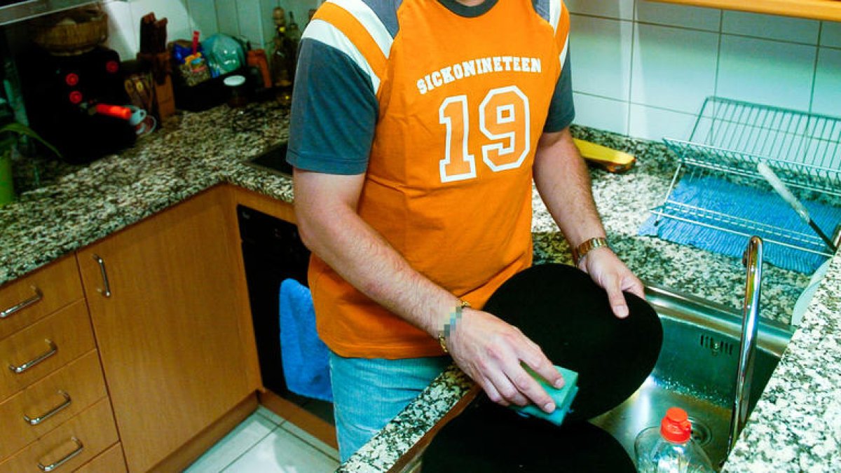 Un home rentant els plats.