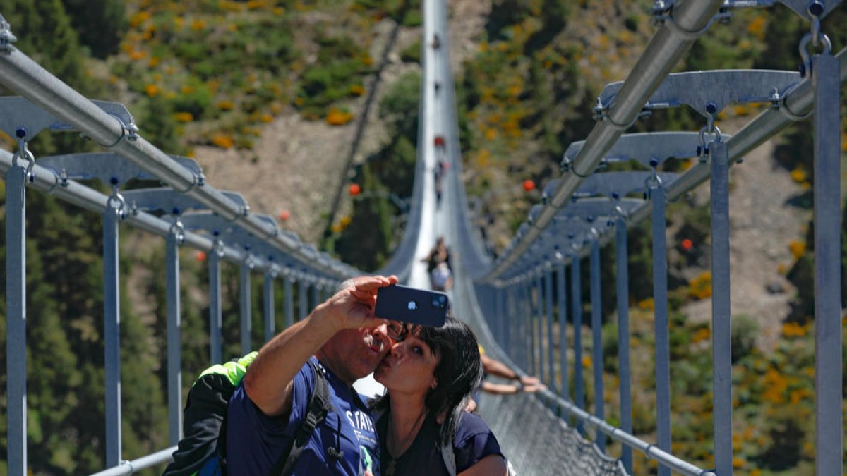 Un grup de visitants passejant pel pont tibetà.