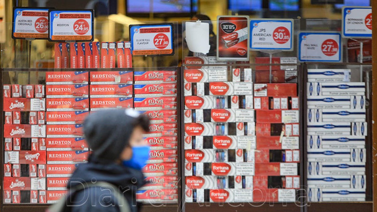 Un vianant passant per davant d'una botiga de venda de tabac.