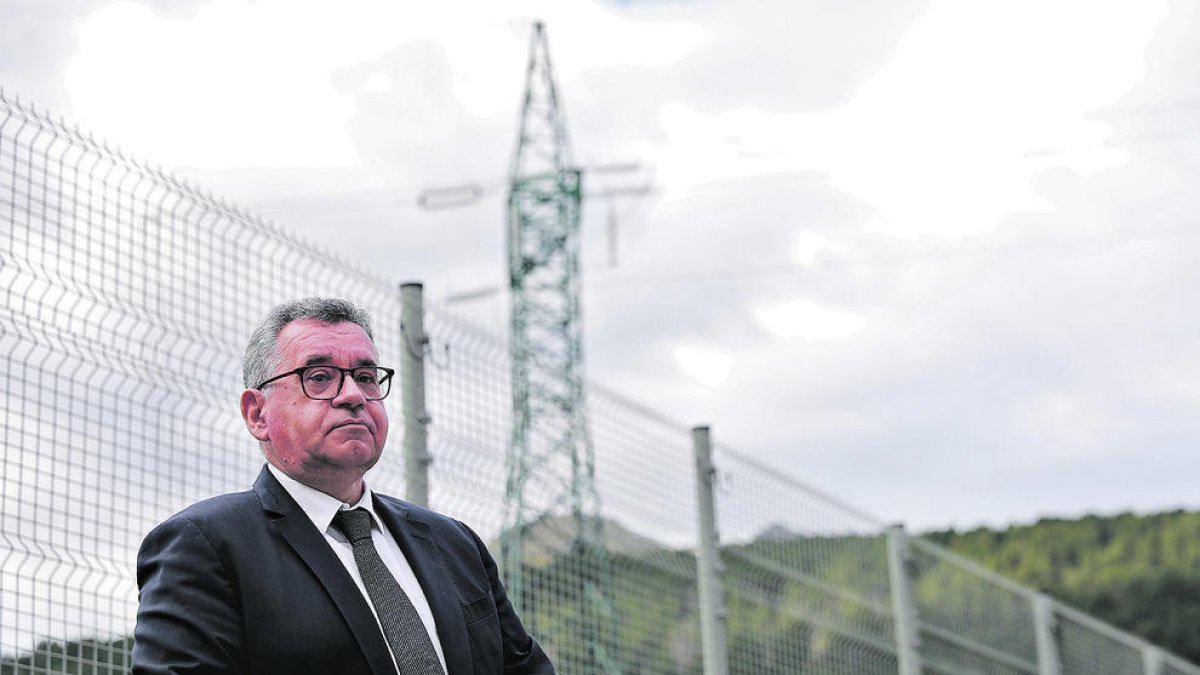 Albert Moles, director general de FEDA, amb una torre d'alta tensió al fons.