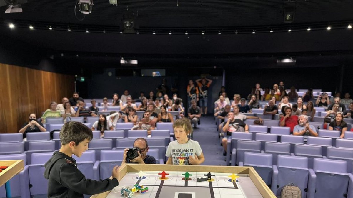 Dos nens participant a una activitat de robòtica.