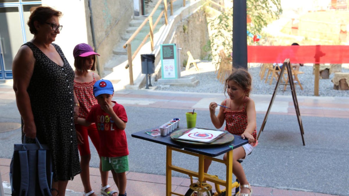 Nens pintant a les taules giratòries.