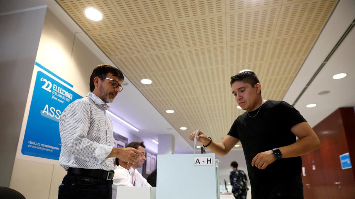 Un votant posant la papereta a l'urna.