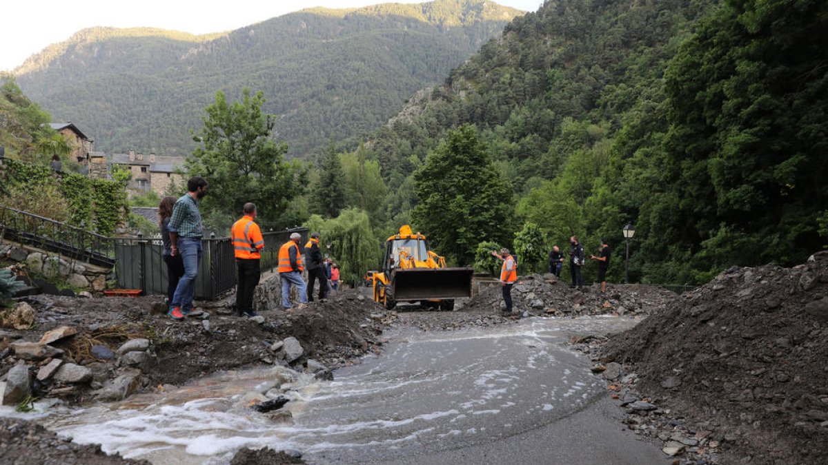 Una màquina treballant a la carretera de Bixessarri, destrossada arran d'una torrentada, el juliol de l'any passat.