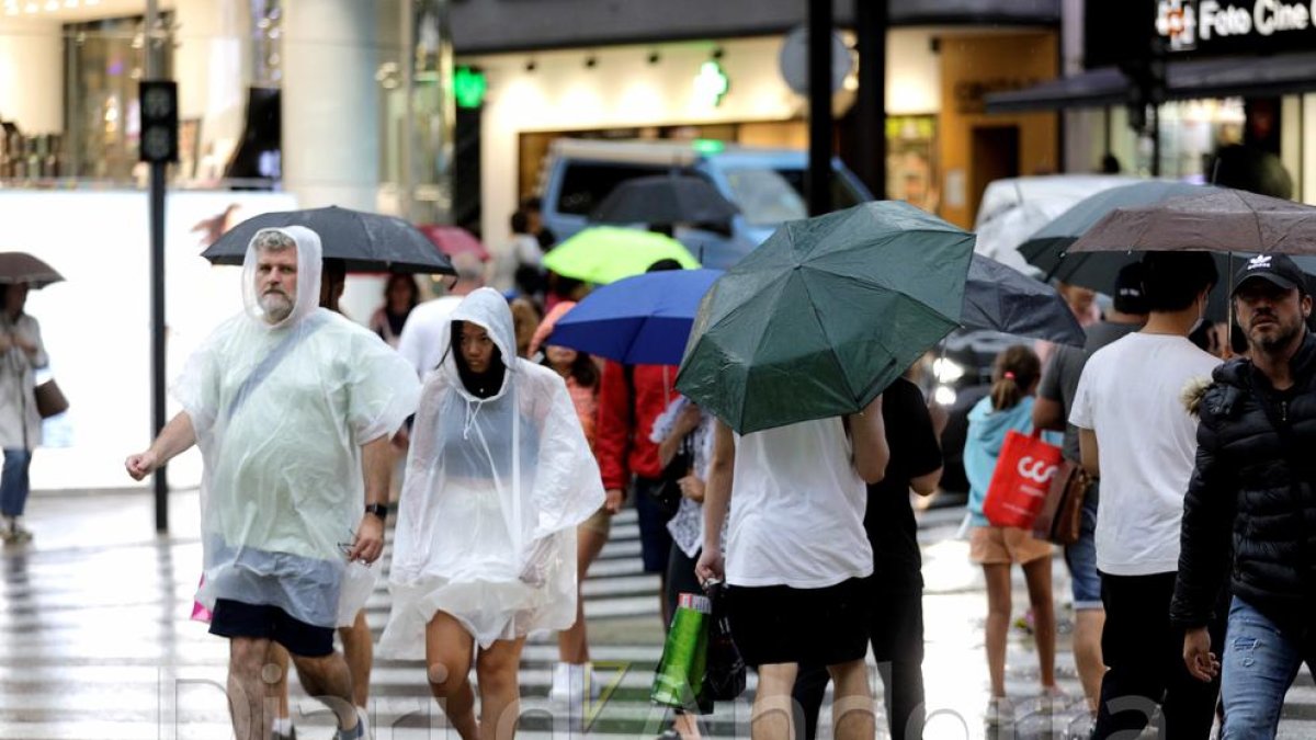 Gent passejant amb paraigües aquesta tarda