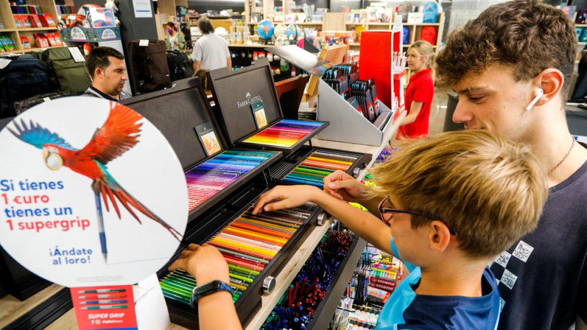 Dos nens escollint material escolar a l'establiment Ofijet.