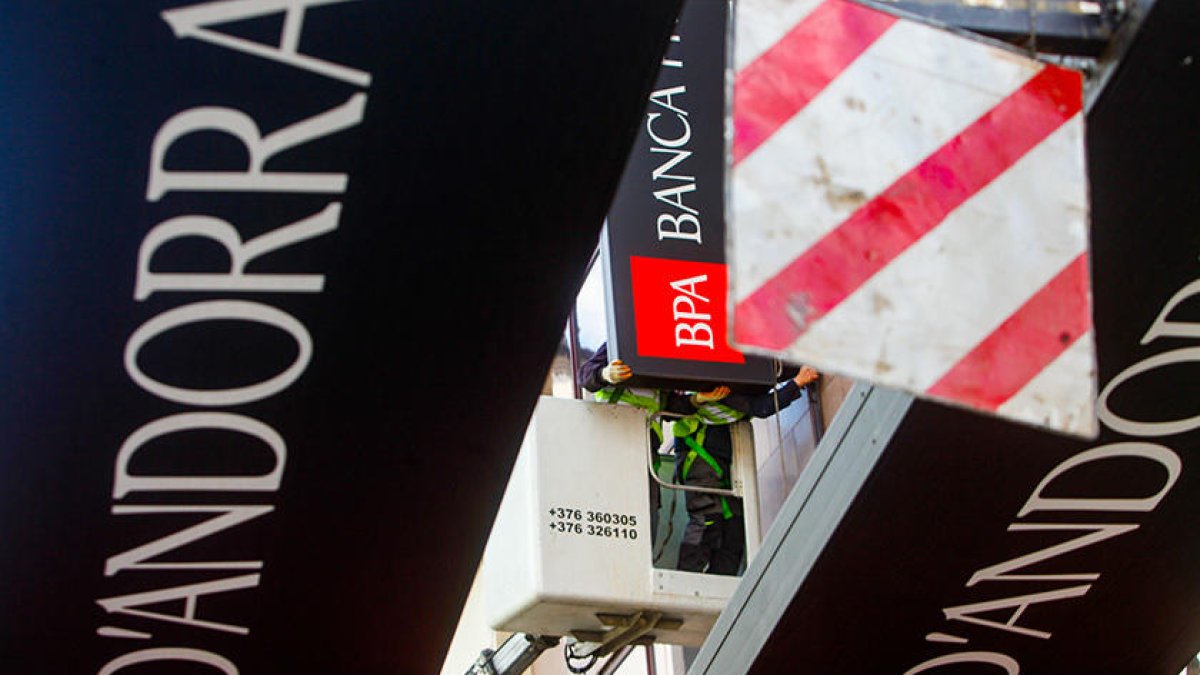 Operaris traient els cartells d'una de les oficines de l'antiga BPA.