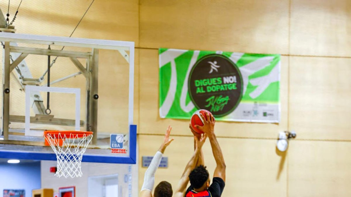 Felipe dos Anjos lluitant per un rebot amb dos jugadors del CB Prat, ahir.