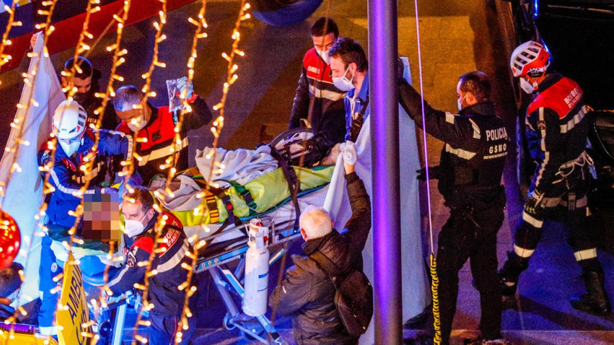 Els bombers enduent-se l'home ferit en ambulància.