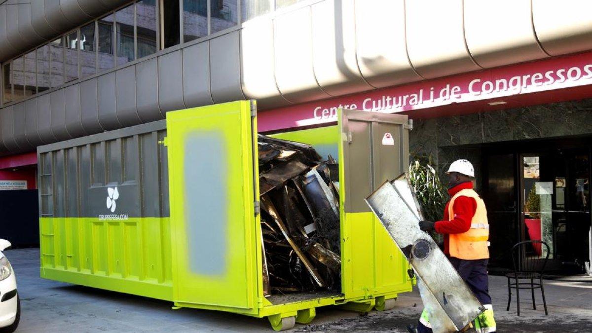 Els operaris retirant mobiliari i material destrossat pel foc