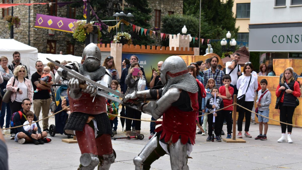 Dos cavallers, amb armadures i armes d'època, lluiten a la plaça de la Germandat de Sant Julià de Lòria.