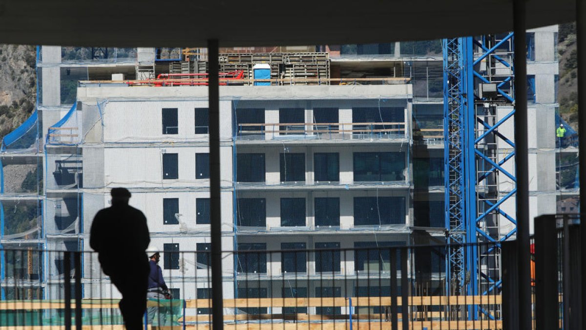 Un jubilat observa les obres de construcció d'un immoble.