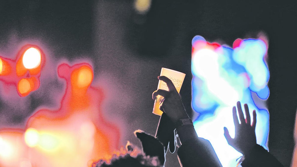 Un jove alça un got de festa.