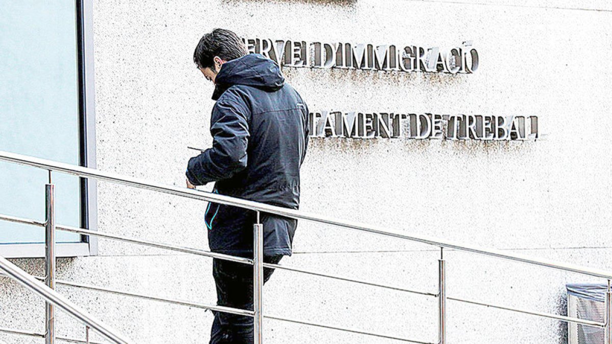 Una home espera per entrar al servei d'immigració.