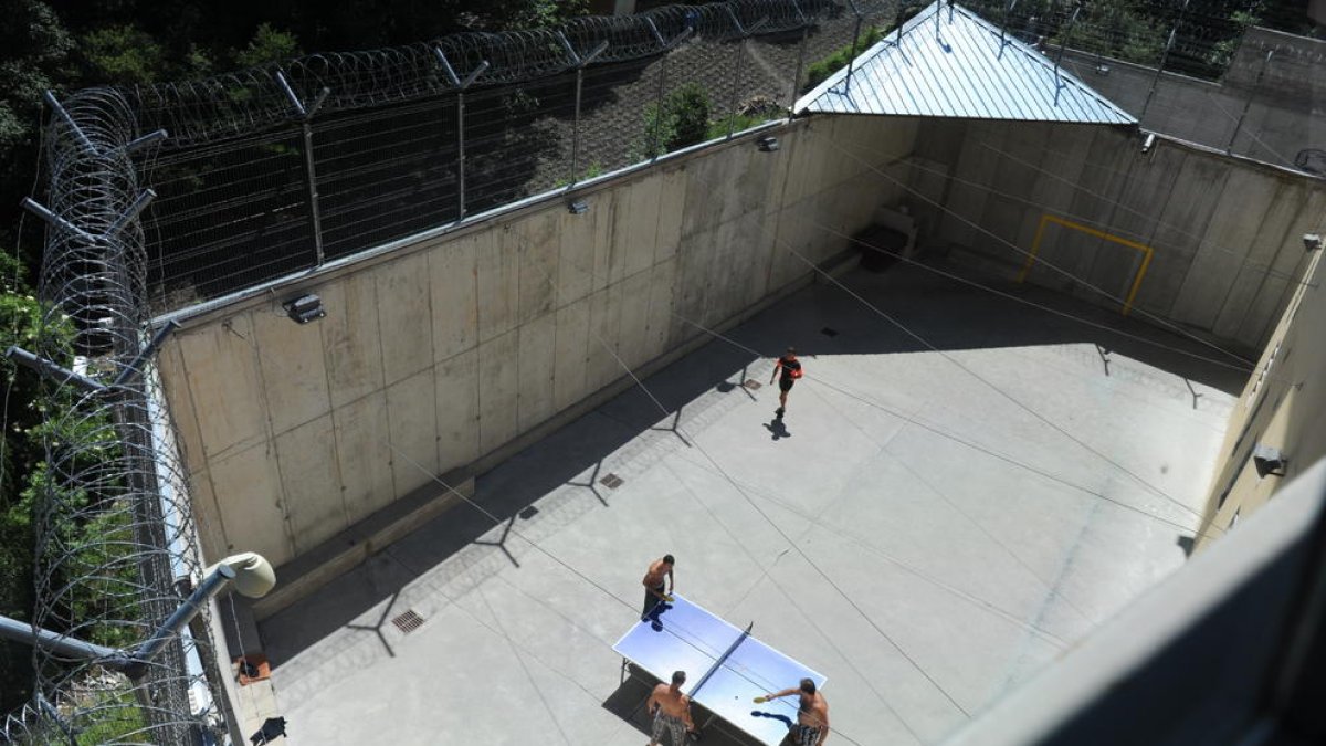 Uns interns jugant a tennis taula al pati de la presó