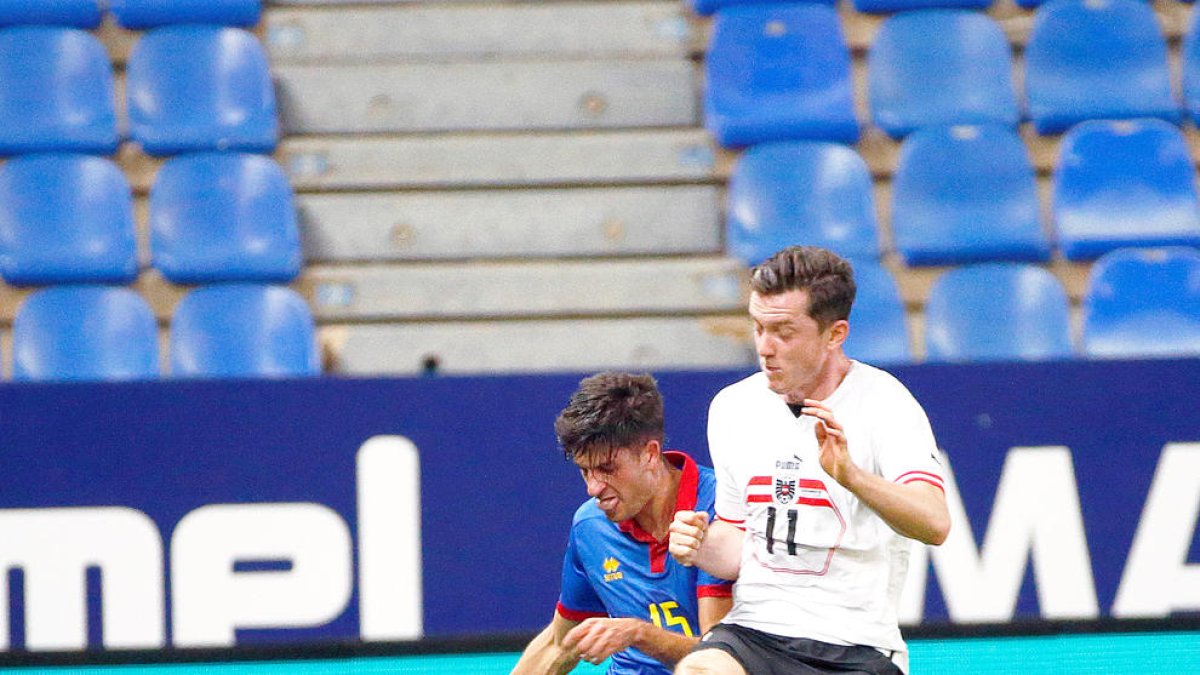 Guillén rebutjant la pilota davant un jugador austríac.