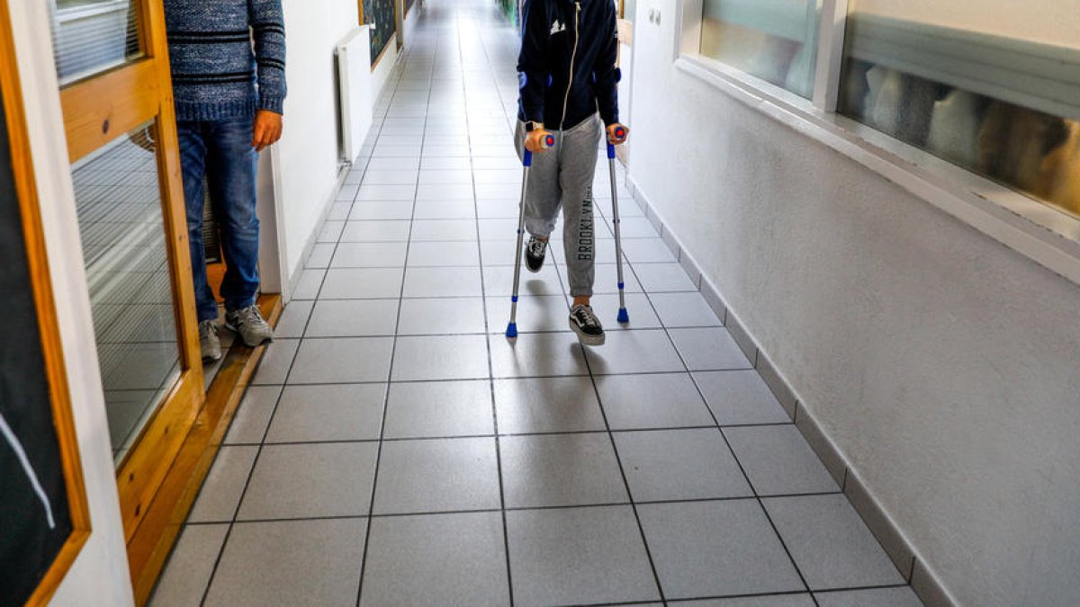 Una noia amb crosses per un passadís de la CASS.