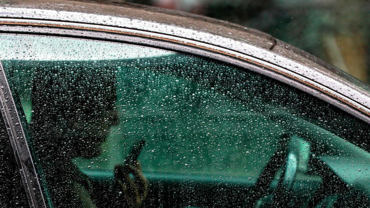 Una persona utilitzant el mòbil mentre condueix.