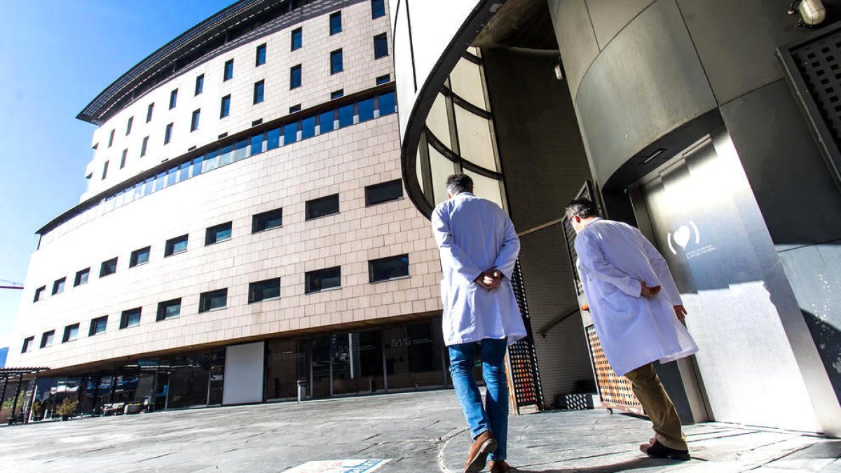 Dos treballadors del SAAS a l'entrada de l'hospital de Meritxell.