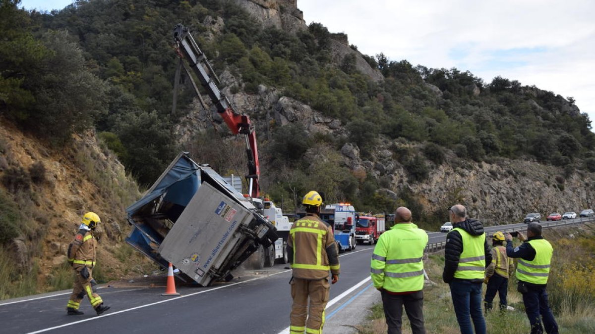 Una grua aixeca el camió bolcat per l'accident a la C-14
