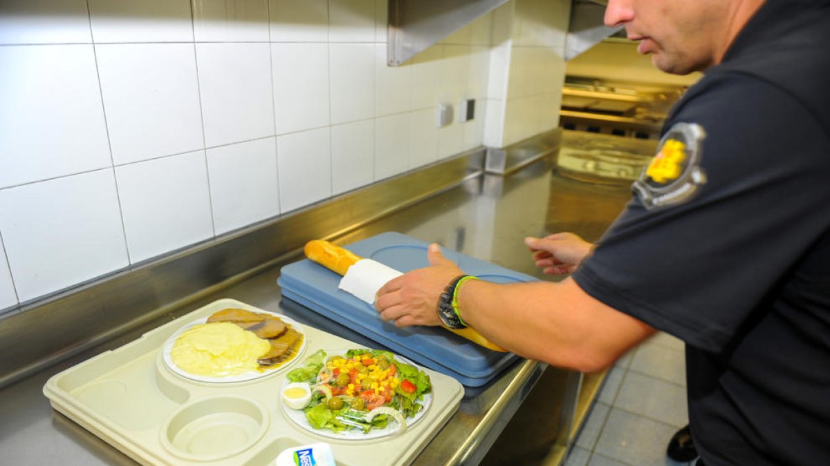 Un carceller preparant el menjar.