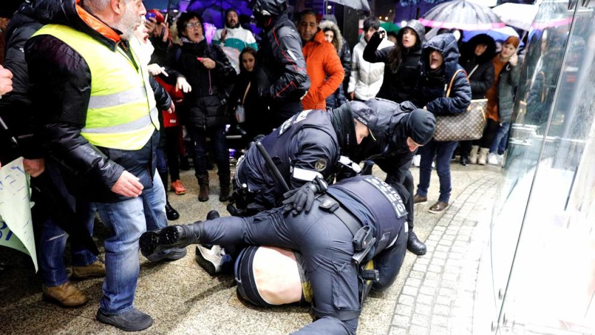 Tres agents de policia controlant al manifestant que va ser detingut