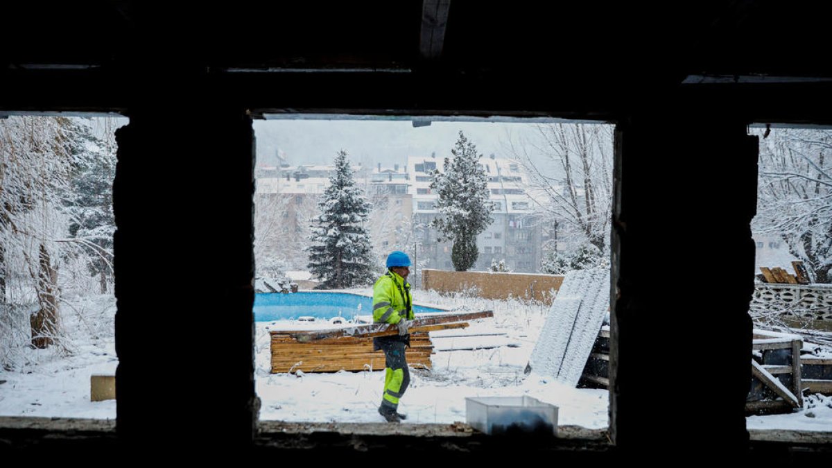 Un operari treballant sota la neu als terrenys de l'antic càmping Internacional, a Encamp.