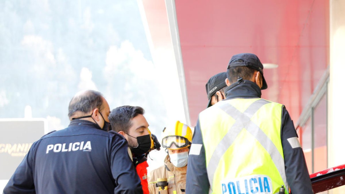 Les autoritats davant d'un cotxe estavellat contra un supermercat del país.