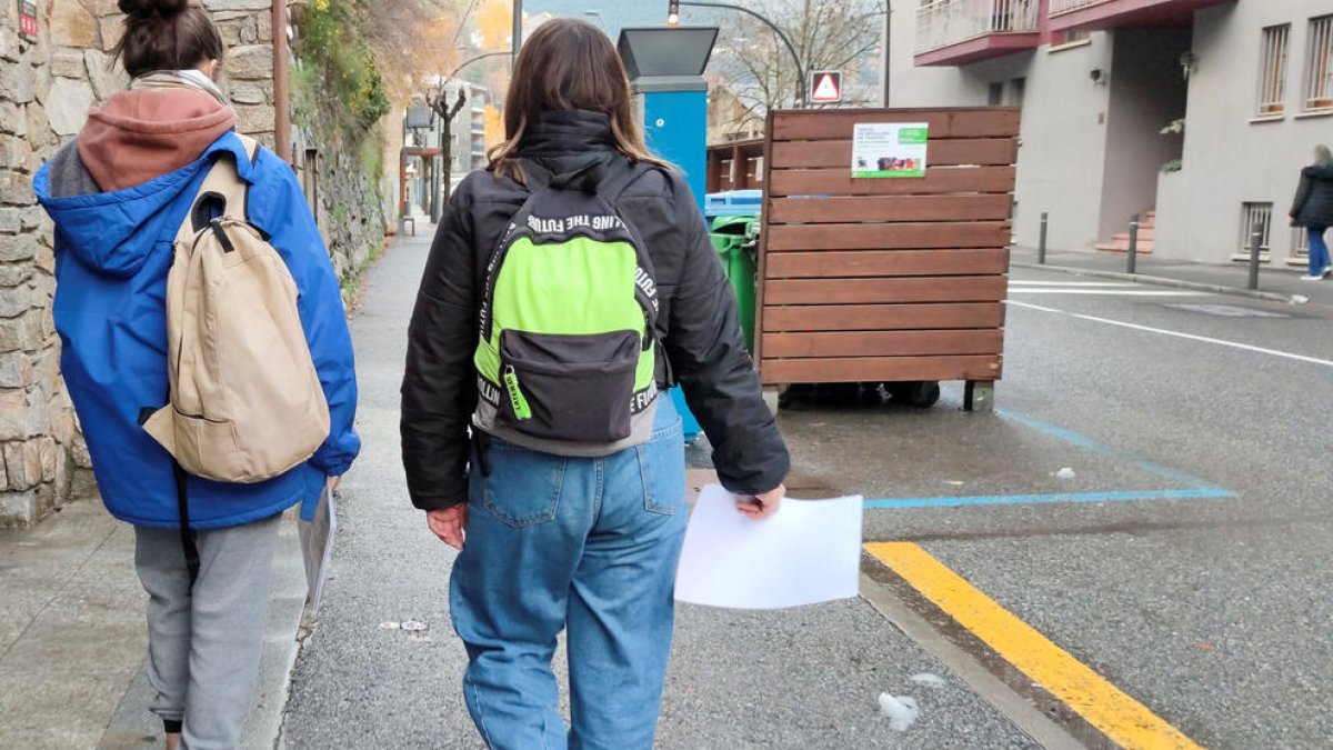 Dues noies reparteixen currículums a la recerca de feina.