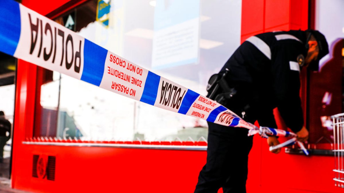 Un agent de policia acordonant una zona.