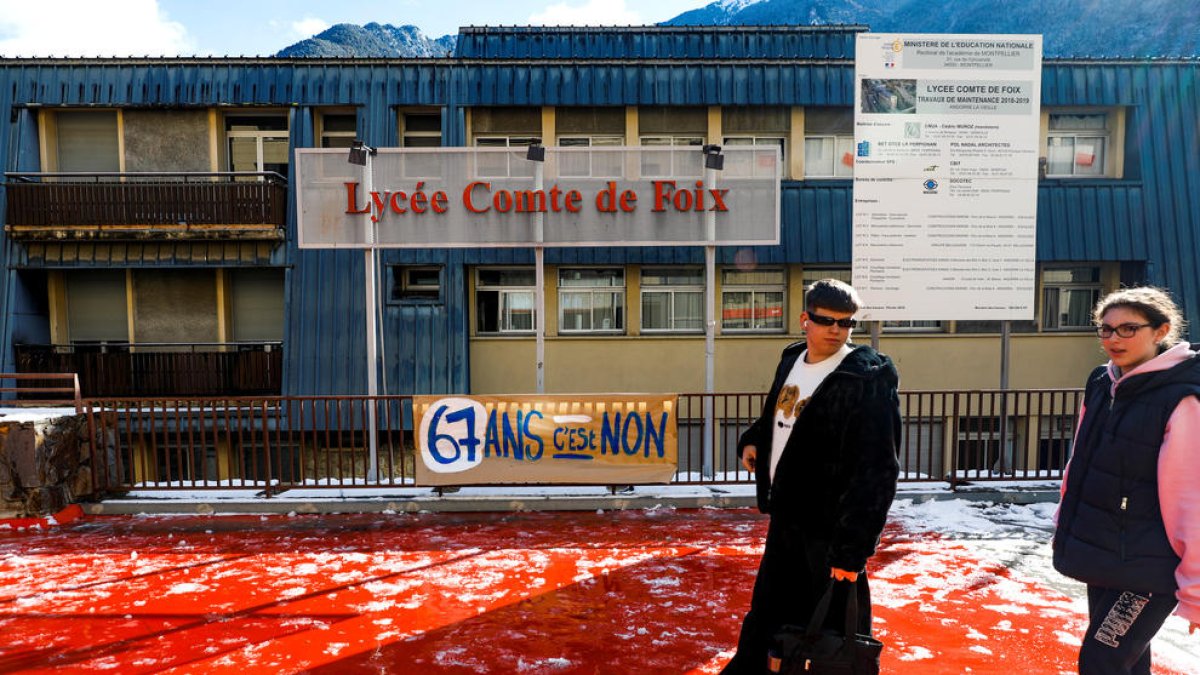 Escolars passant davant de la pancarta penjada pels professors en vaga.