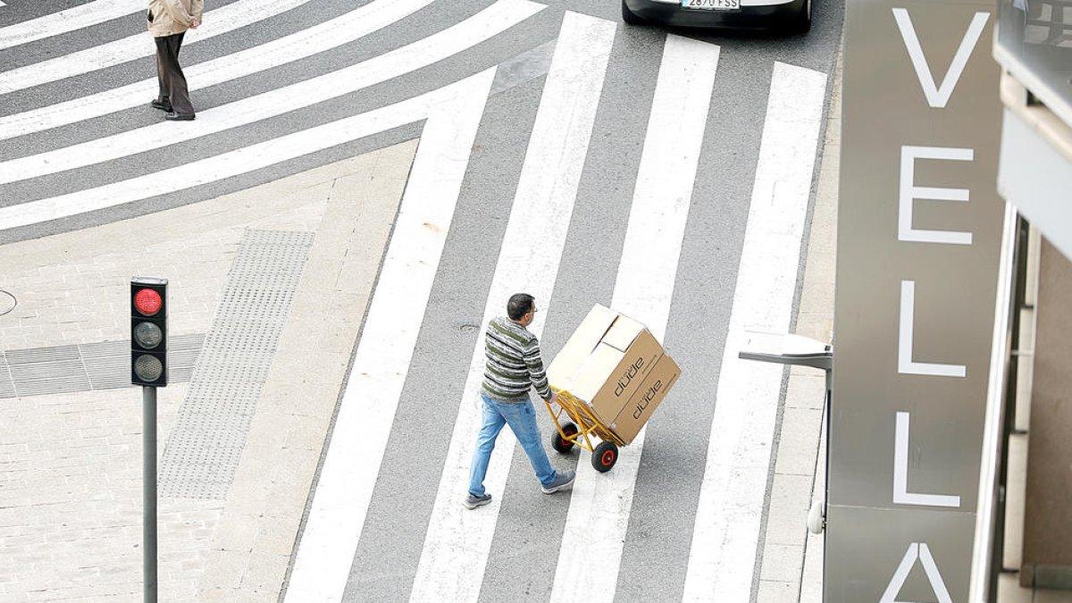 Una persona transportant una caixa a Andorra la Vella.