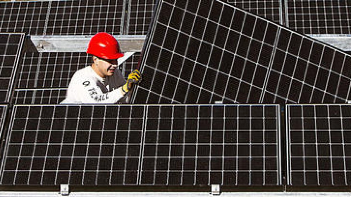 Un operari instal·lant plaques fotovoltaiques.