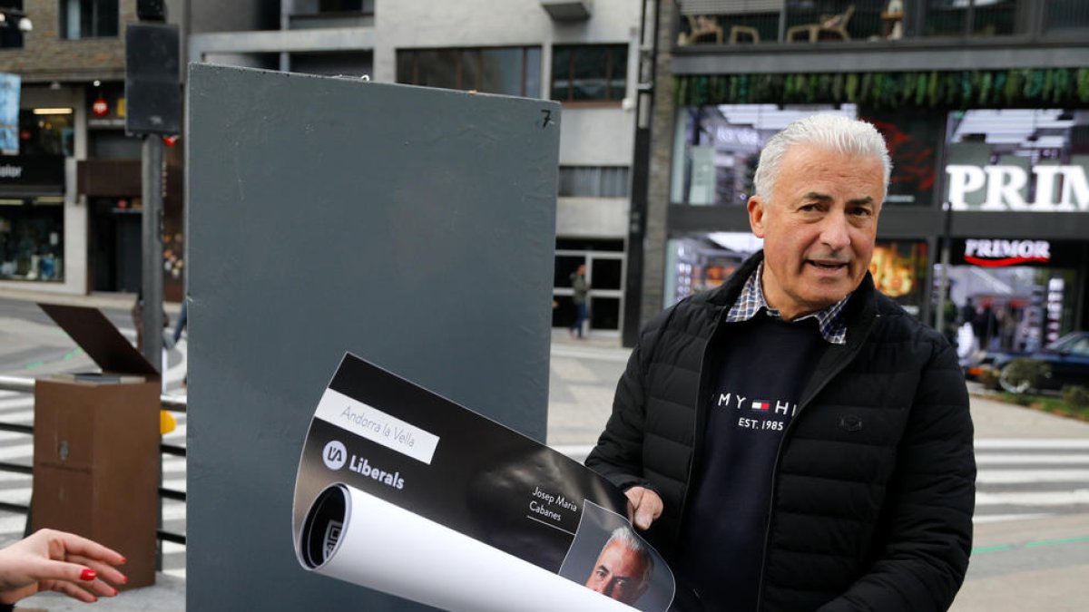 El cap de llista liberal amb un dels cartells electorals a la mà.