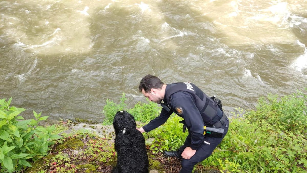 Un dels agents de policia amb el gos rescatat.