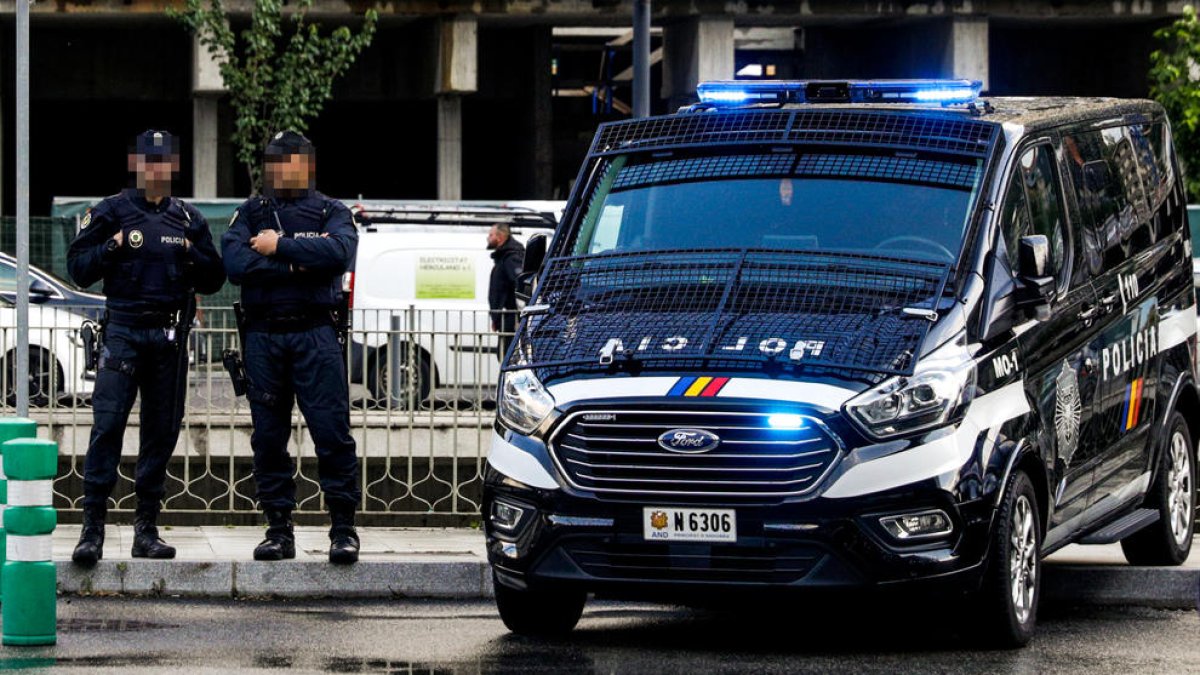 Dos agents de policia al costat d'una furgona del cos.