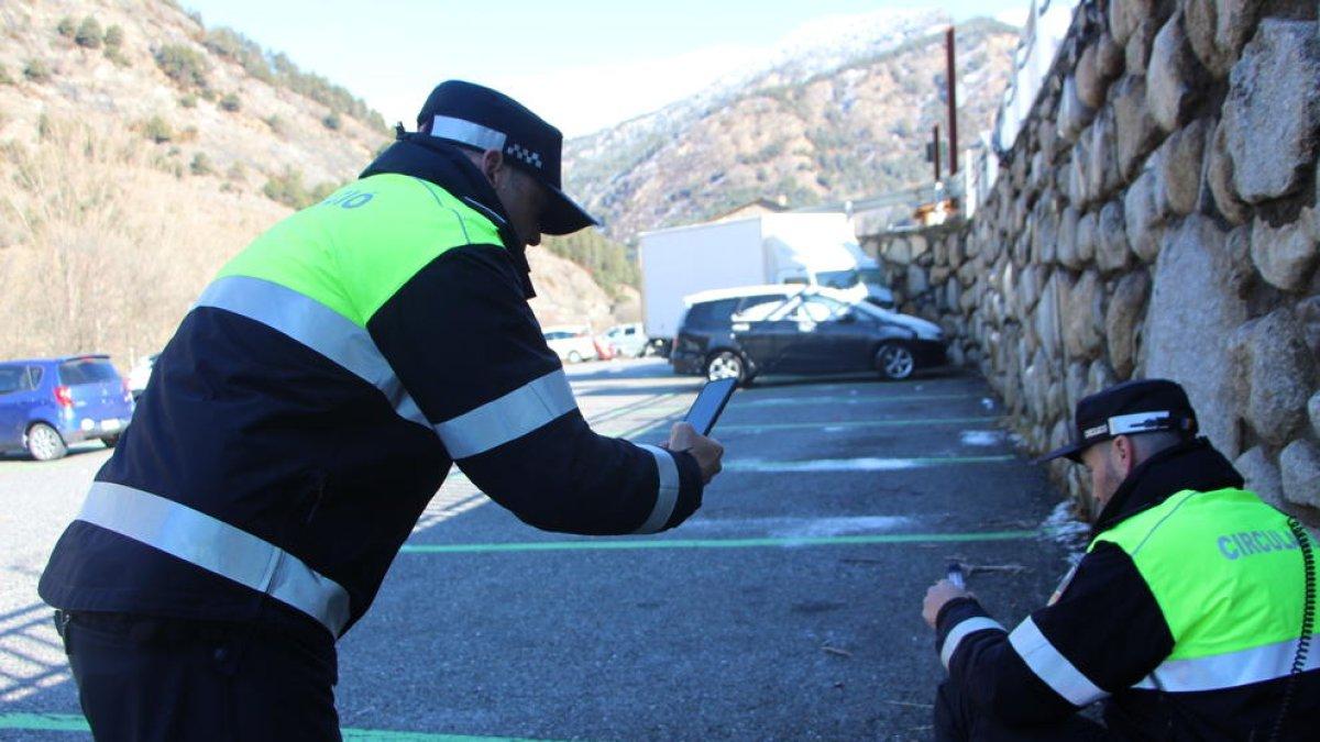 Dos agents d'Ordino recollint excrements de gossos