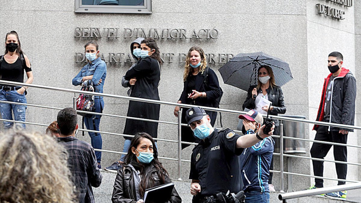 Persones fent cua al servei d'Immigració.