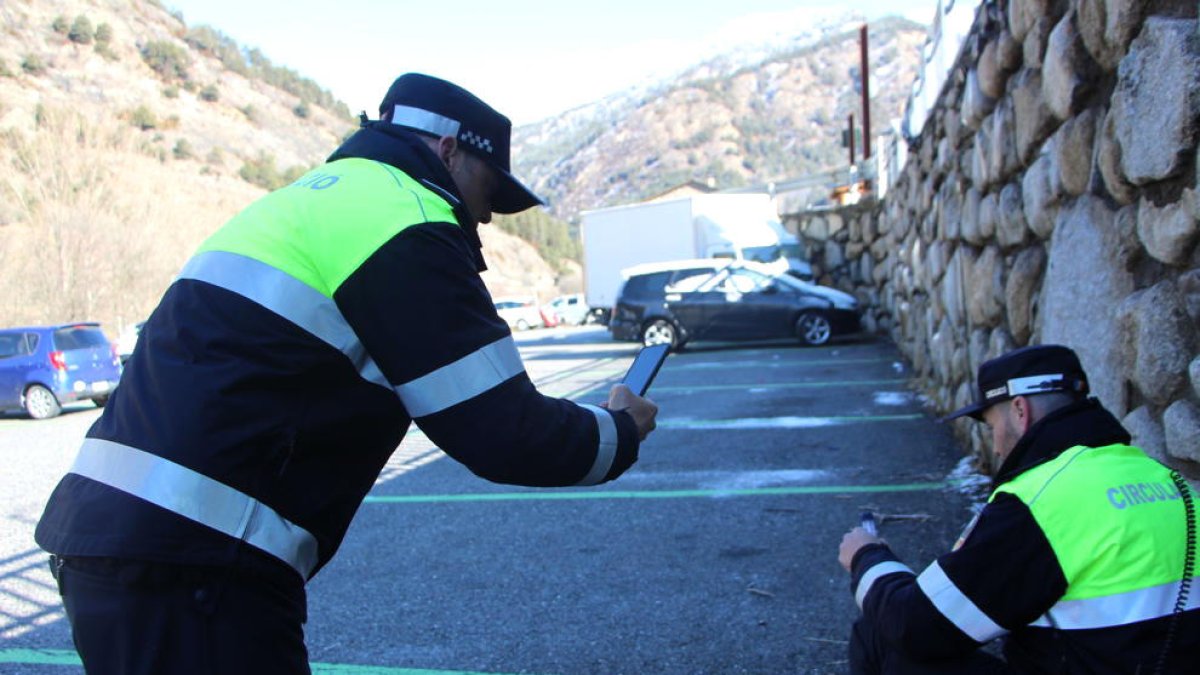 Dos agents de circulació recollint els excrements d'un gos.