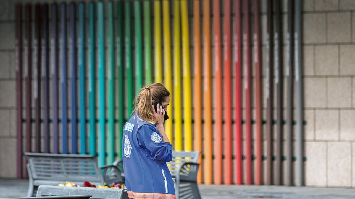 Una sanitària atenent una trucada a la plaça de l'hospital.