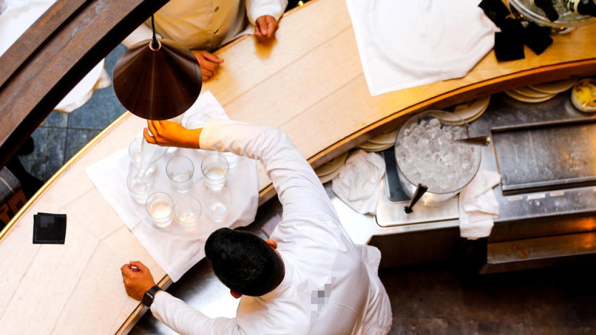 Un cambrer servint gots d'aigua