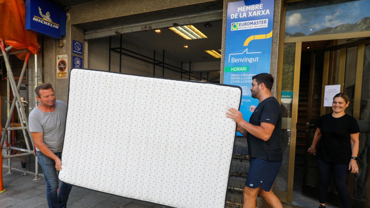 Veïns de l'edifici número 28 emportant-se un matalàs.