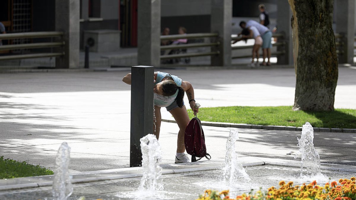 Una noia bevent aigua durant la primera onada de calor del mes.