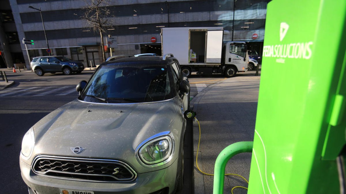 Un vehicle carregant-se en un dels punts habilitats al carrer.
