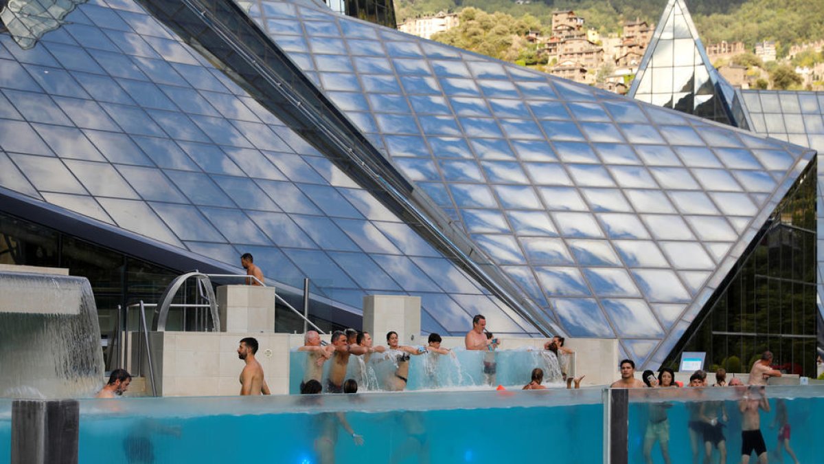 Turistes a la piscina exterior de Caldea.