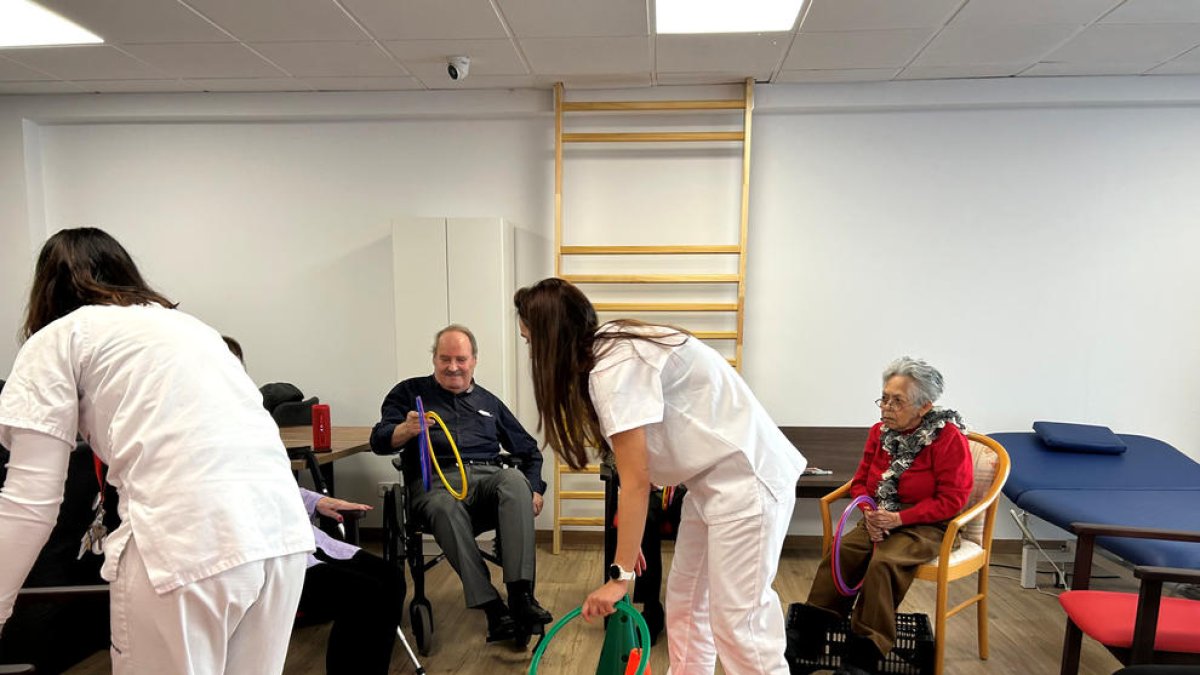 Una auxiliar fent jocs amb els avis.