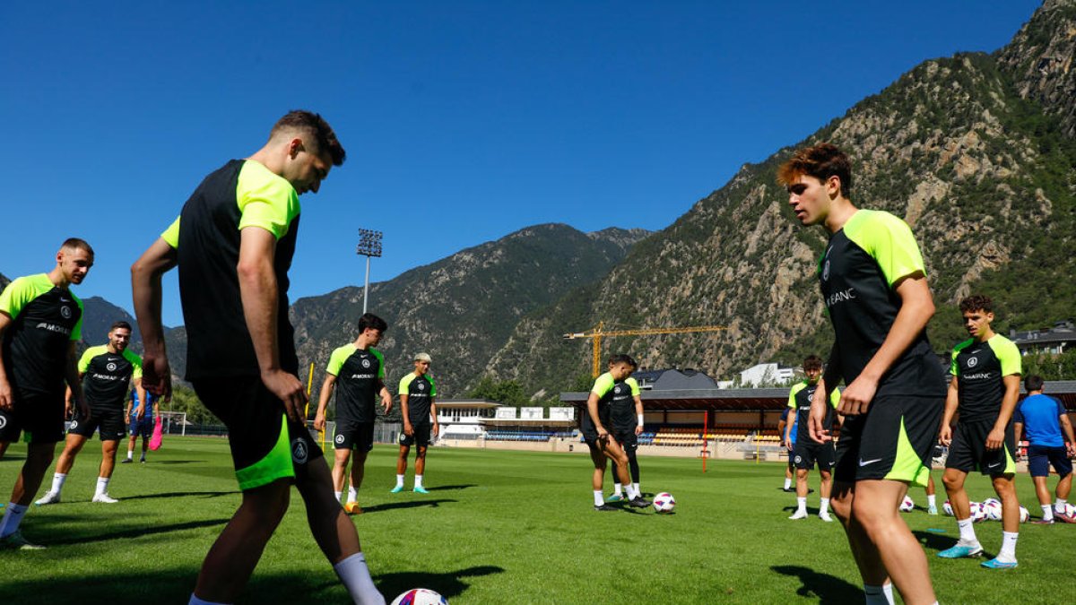 Un grup de jugadors tricolors exercitant-se a la gespa de l'Estadi Comunal Joan Samarra.