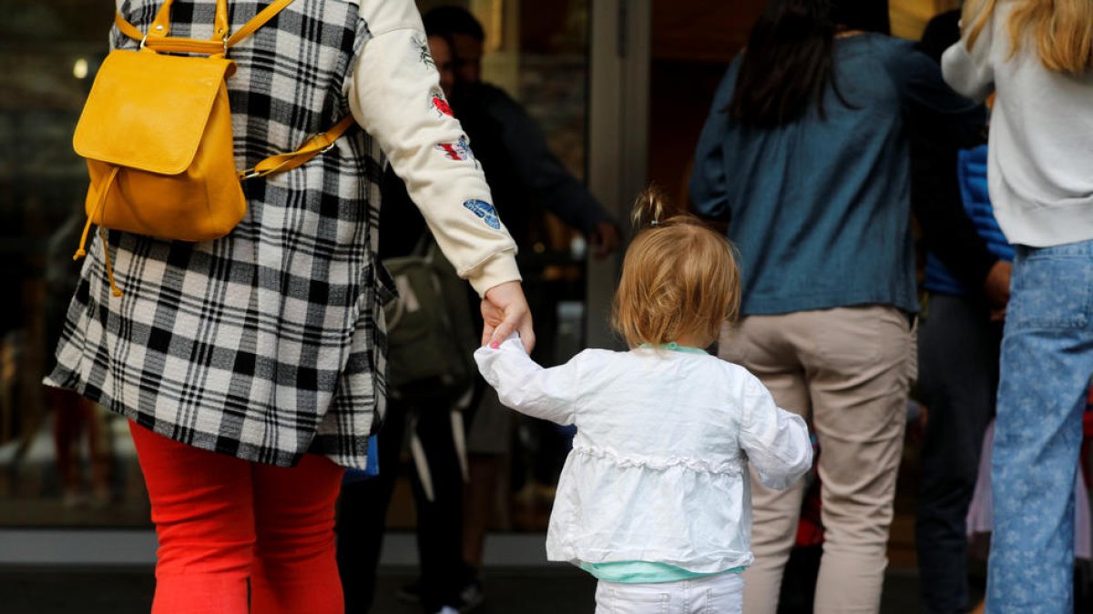 Una mare entrant amb la filla a l'escola.