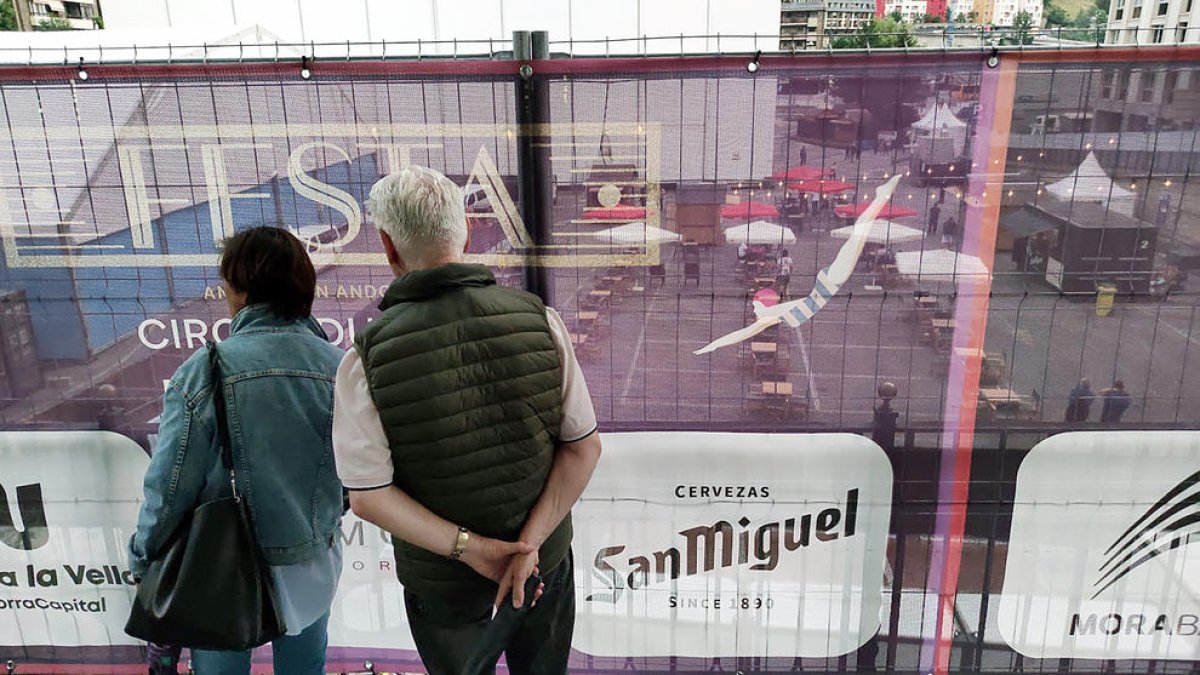 Dues persones observant des de fora el recinte del Cirque i la part de restauració.